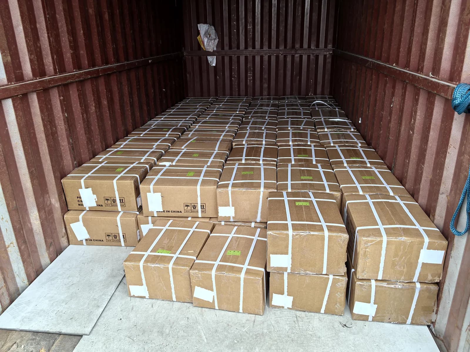Cartons stacked and strapped inside a shipping container