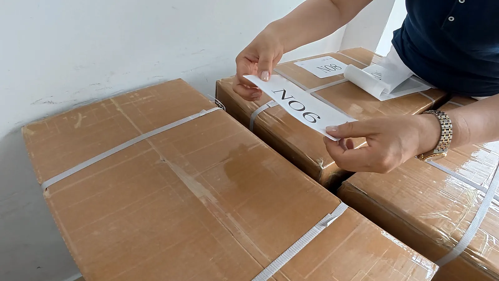 A carton-number label being applied to a packed carton